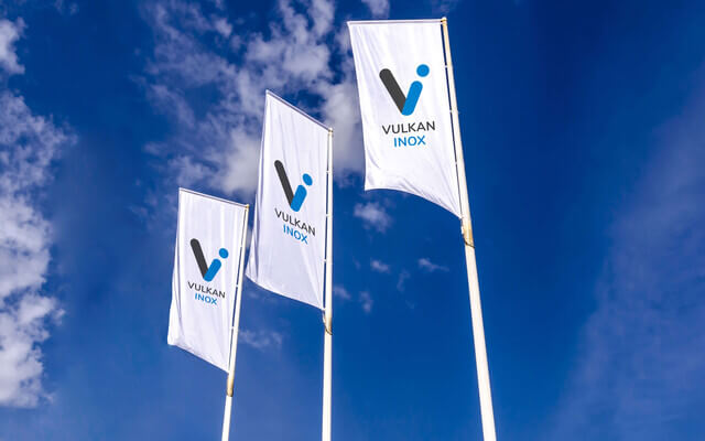 White Vulkan Inox flags against a blue sky.