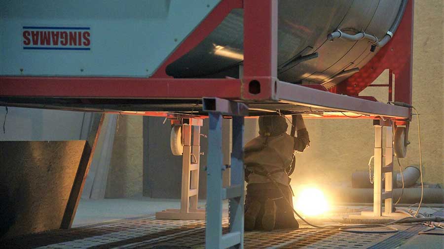 Worker cleaning a chemical tank.